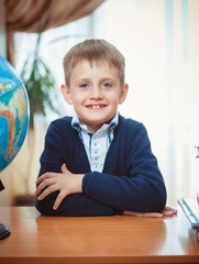 A schoolboy sits at a desk