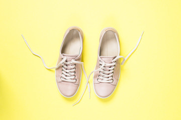 Woman fashion pink shoes on yellow background.