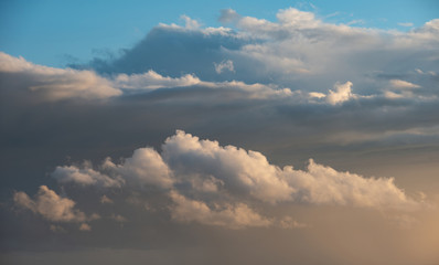 Beautiful cumulonimbus stormy rain cloud formations in Summer sunset sky with dramatic moody color...