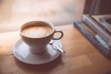 Kaffeetasse mit Cappucino in Café auf Holztisch, Morgen 