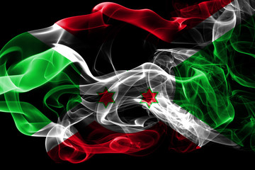 National flag of Burundi made from colored smoke isolated on black background. Abstract silky wave background.