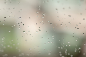 Close up of rain drops on glass with sun light.