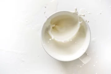 Rolgordijnen top view of milk splash out of glass on white background © antpkr