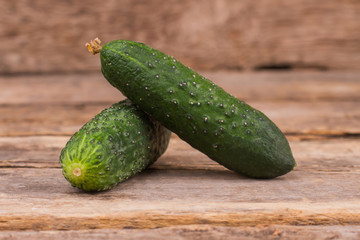 Two cucumbers on the table. Wooden desk surface background.