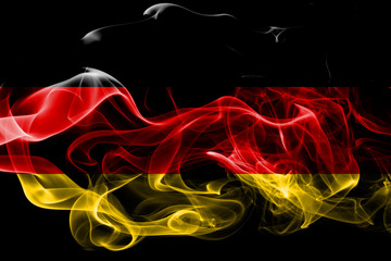 National flag of Germany made from colored smoke isolated on black background. Abstract silky wave background.