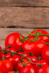 Bunch of red tasty fresh tomatos on the wooden background. Close up. Washed vegetables.