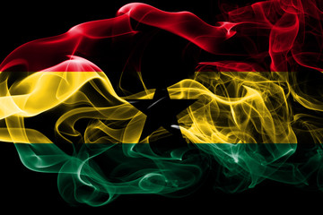 National flag of Ghana made from colored smoke isolated on black background. Abstract silky wave background.