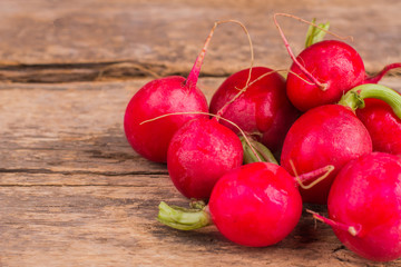 Pile of multiple radishes. Close up. Old vintage wooden desk table background.