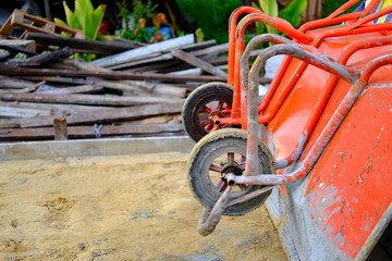 Fototapeta na wymiar Orange Two wheelbarrow or Trolley for construction in site building area - Construction industry concept