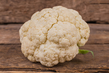 Fresh ripe raw cauliflower on wood. Close up. Rustic wooden background.