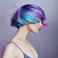 Portrait of a woman with bright colored flying hair, all shades of purple. Hair coloring, beautiful lips and makeup. Hair fluttering in the wind. Sexy girl with short hair