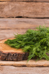 Green dill and wooden cut board. Cooking salad. Wooden rustic table background.