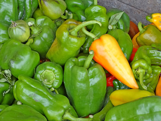 Lots of green and one red peppers