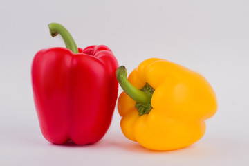 Red and yellow paprika bell pepper over white isolated background. Close up. Fresh ripe vegetable.
