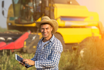 Farmer with combine harvester in field