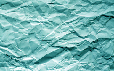 Crumpled sheet of paper with blur effect in cyan tone.