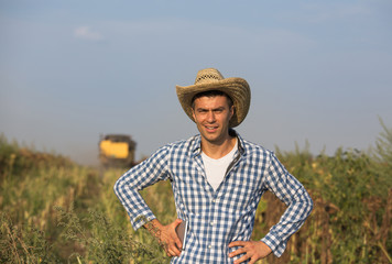 Fototapeta premium Farmer with combine harvester in field