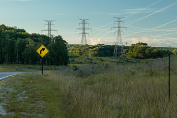Power Electrical Lines From Hydro Electric Plant by Road and Field with Sign 