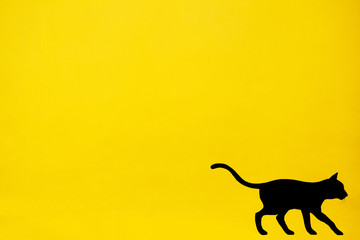 Black cat painted on yellow wall.