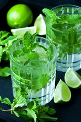Mojito cocktail with lime and mint on  black background.