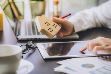 Hand of Business people calculating interest, taxes and profits to invest in real estate and home...