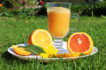 Orange freesh jusse with orange on green grass background