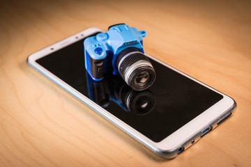 Small DSLR camera toy over a Smartphone.
