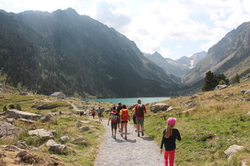 Fototapeta na wymiar Randonnée en montagne avec randonneurs sur chemin arrivée au lac