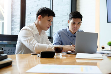Business partner talking and consult with laptop computer and paper document.
