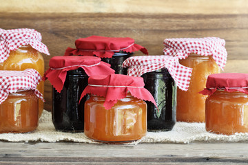 Wooden spoon full of homemade Cantaloupe Jam resting in an open jar filled with jam. Could also be peach jam.