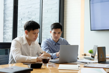 Business partner talking and consult with laptop computer and paper document.