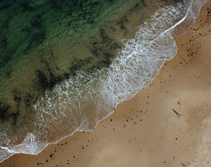 Seascape with waves and shadows of walking people. Top view aerial photo from flying drone of...