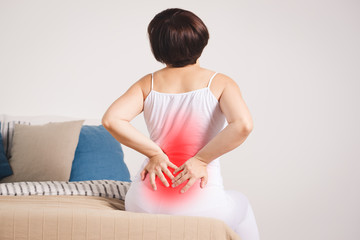 Back pain, kidney inflammation, woman suffering from backache at home