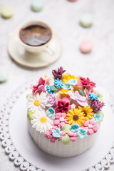Cake from marzipan flowers macaroons and  black coffee.