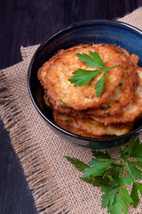 Vegetable pancakes topped with parsley leaves in a blue bowl