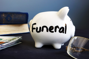 Funeral plan written on a side of piggy bank.