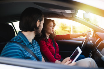 Driving school or test. Beautiful young woman learning how to drive car together with her instructor