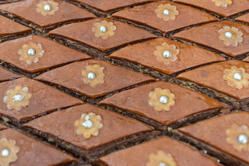 Naklejka premium Sweet pie with nuts in the form of pearls macro in baked sliced slices. Horizontal. Selective focus. Asian cuisine.