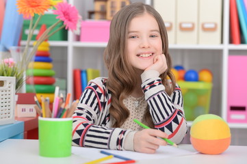 Portrait of a cute little girl doing homework