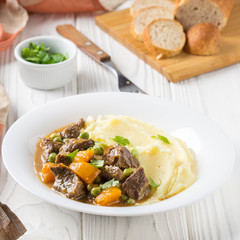 Beef stew, pumpkin and green peas with mashed potatoes.  Delicious homemade dinner. Autumn food