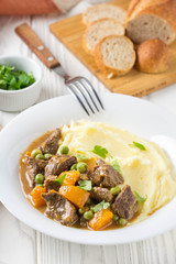 Beef stew, pumpkin and green peas with mashed potatoes.  Delicious homemade dinner. Autumn food