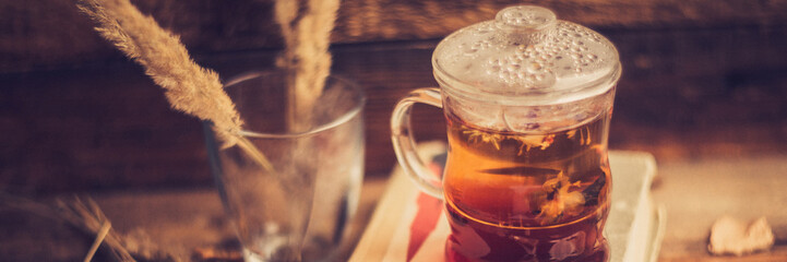 green circle in the scarf, the window with maple leaves and drops after rain in autumn / season when you need warm drinks