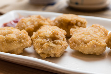 Golden fried chicken nuggets on white plate