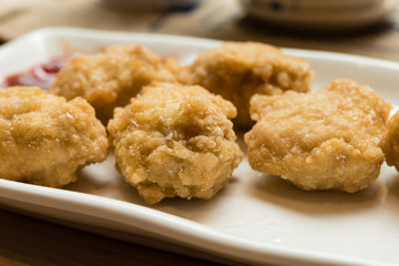 Golden fried chicken nuggets on white plate