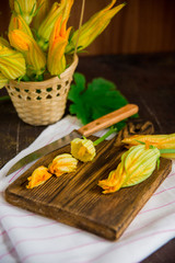 Edible flowers, zucchini blossoms on brown natural background