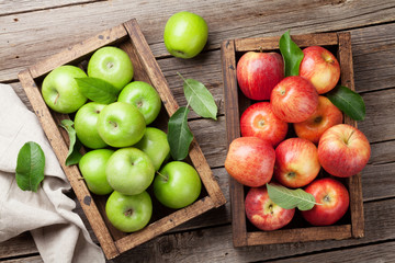 Green and red apples in wooden box