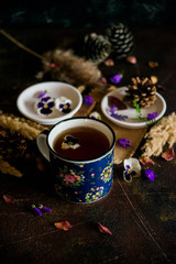 Obraz na płótnie Canvas Tea with edible flowers, pansies. The concept of a cozy home autumn tea party