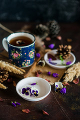 Tea with edible flowers, pansies. The concept of a cozy home autumn tea party
