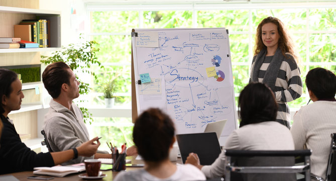 Young business woman giving presentation on future plans to his colleagues at office
