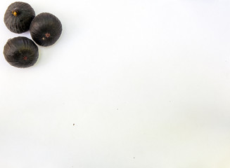 Fresh ripe sweet figs on white paper with copy space.